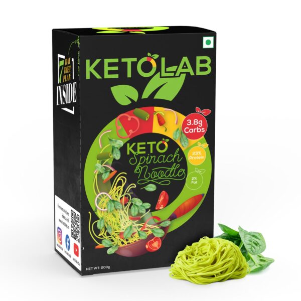 Ketolab Spinach Noodles product box with vibrant vegetable graphics and bold labeling showing 3.8g carbs, 23% protein, and 2% fat. Fresh green spinach noodles and spinach leaves placed beside the box.